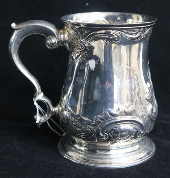 An early George III silver mug with later embossed decoration and later inscription to the base, London, 1760, 11 oz.